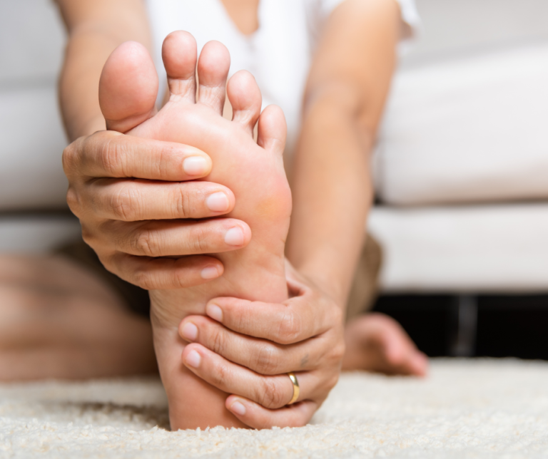 person holding foot with nerve pain